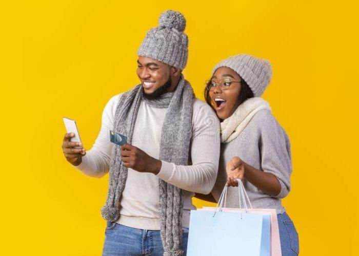 cheerful-black-guy-girl-shopping-online-smartphone-winter-african-woman-holding-bags-man-credit-card-yellow-background-164927790 cheerful-black-guy-girl-shopping-online-smartphone-winter-african-woman-holding-bags-man-credit-card-yellow-background-164927790